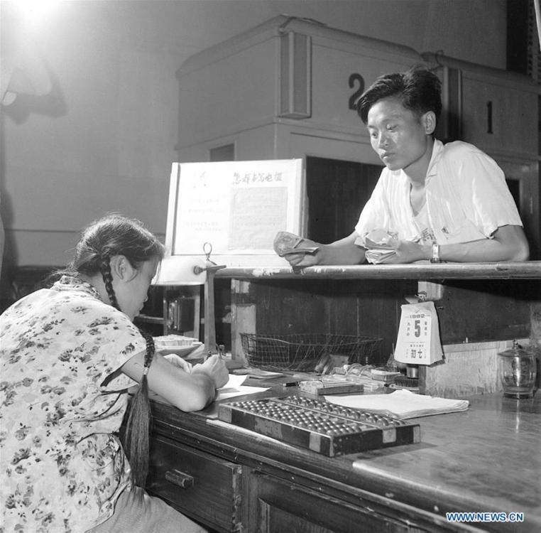 Photo taken on Aug. 30, 1962 shows telegraph operator Li Huiqing (L) helps a man send a telegram at Dongsi telecom bureau in Beijing, capital of China. More than four decades of sound economic growth from 1978, the starting year of the reform and opening-up policy, has fundamentally lifted life quality of 1.3 billion Chinese, who are now able to enjoy the \