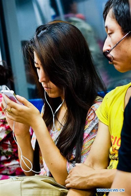 A passenger plays games with the mobile phone on Beijing subway line 2 in Beijing, capital of China, July 18, 2012. More than four decades of sound economic growth from 1978, the starting year of the reform and opening-up policy, has fundamentally lifted life quality of 1.3 billion Chinese, who are now able to enjoy the \