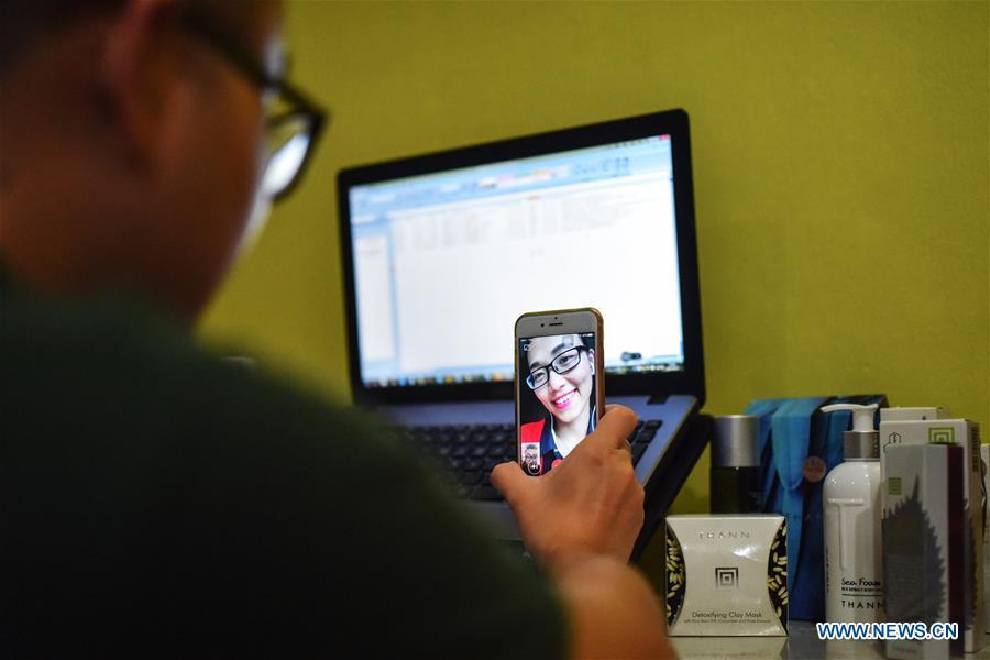 Chen Yu, a Chinese graduate working in Bangkok, talks with his girl friend, who stays in China, via a video call at his home in Bangkok, Thailand, June 12, 2016. More than four decades of sound economic growth from 1978, the starting year of the reform and opening-up policy, has fundamentally lifted life quality of 1.3 billion Chinese, who are now able to enjoy the \