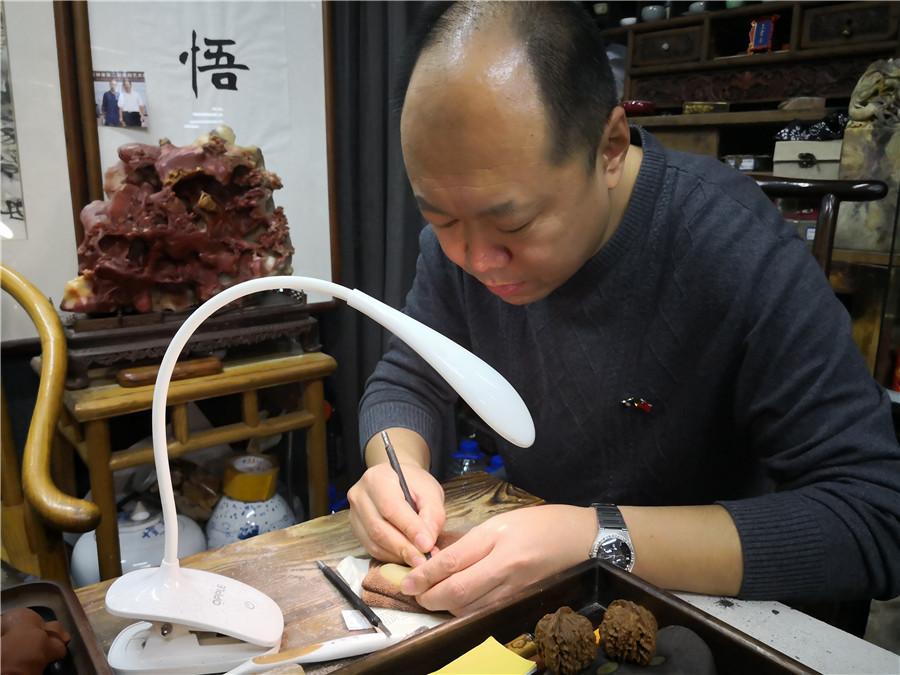 To remain true to tradition, Zhao Qiushi creates the artworks without a microscope. (Photo/chinadaily.com.cn)