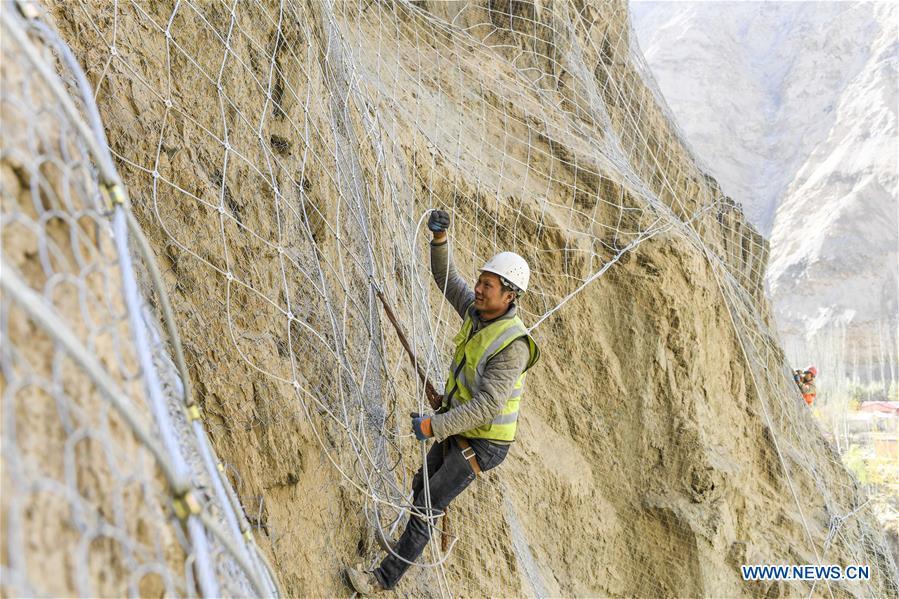 Construction worker Wu Fei installs protective nets on a cliff at a road section in the Tajik Autonomous County of Taxkorgan, northwest China\'s Xinjiang Uygur Autonomous Region, Nov. 12, 2018. The job of this team of construction workers is to install protective facilities on the cliff of risky road sections in the mountainous areas in Xinjiang, protecting pedestrians and vehicles from fallen stones. (Xinhua/Hu Huhu)