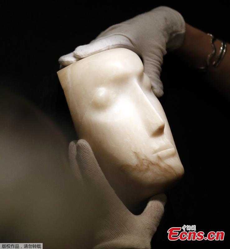 A gallery assistant examines \