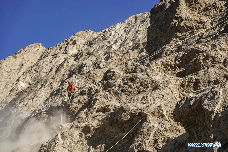 Construction worker Liu Quan works on a cliff at a road section in the Tajik Autonomous County of Taxkorgan, northwest China\'s Xinjiang Uygur Autonomous Region, Nov. 12, 2018. The job of this team of construction workers is to install protective facilities on the cliff of risky road sections in the mountainous areas in Xinjiang, protecting pedestrians and vehicles from fallen stones. (Xinhua/Hu Huhu)