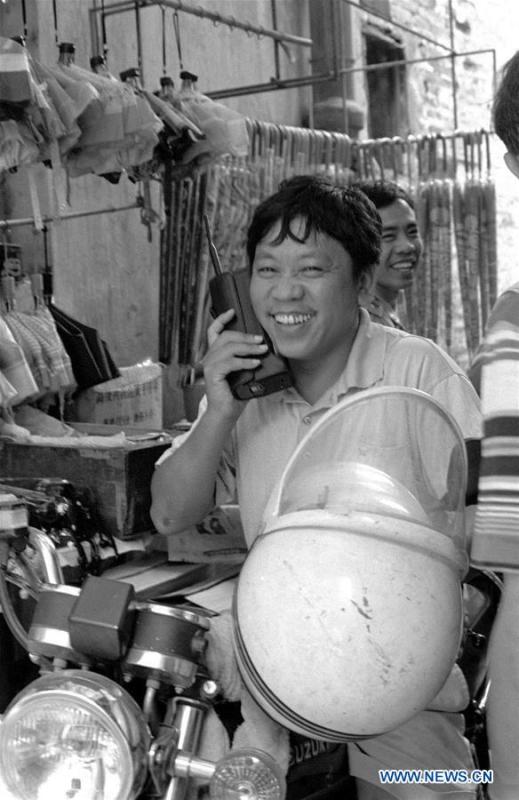 A merchant makes a call with a brick-size cellular phone in Guangzhou, southeast China\'s Guangdong Province, in January of 1994. More than four decades of sound economic growth from 1978, the starting year of the reform and opening-up policy, has fundamentally lifted life quality of 1.3 billion Chinese, who are now able to enjoy the \