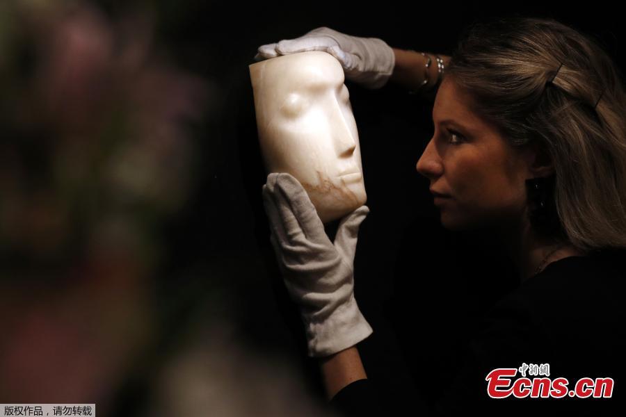 A gallery assistant examines \