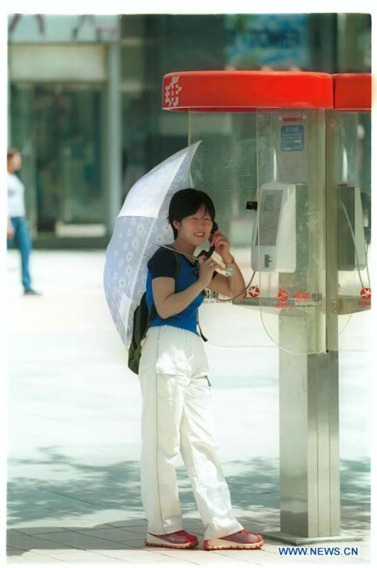 A woman makes a phone call at a phone booth in Beijing, capital of China, May 19, 2001. More than four decades of sound economic growth from 1978, the starting year of the reform and opening-up policy, has fundamentally lifted life quality of 1.3 billion Chinese, who are now able to enjoy the \