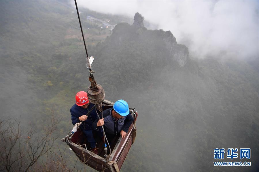 Two water exploration team members are carried in an iron basket to the Tianbao cave in Tianfengping village, Enshi city, Central China\'s Hubei Province, to take water, Nov. 13, 2018. (Photo/Xinhua)
