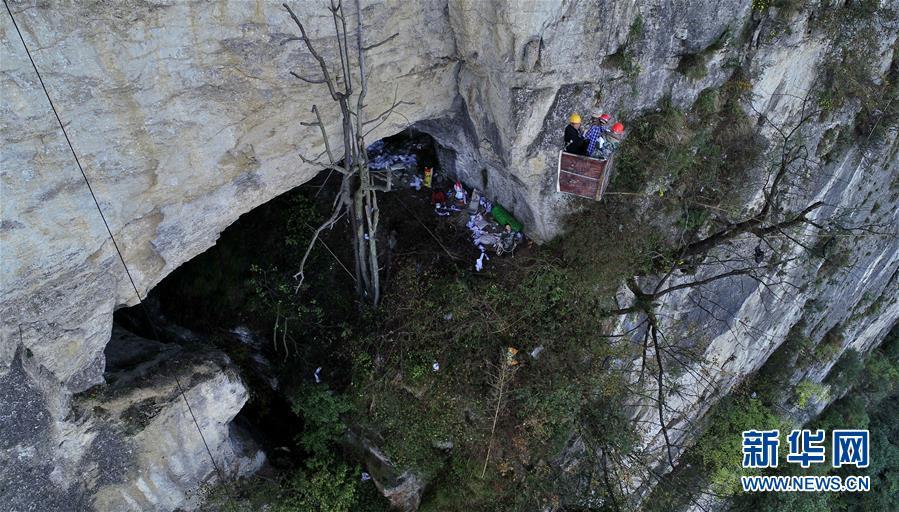 Water exploration team members reach the Tianbao cave in Tianfengping village by being lowered to it in an iron basket, Oct. 31, 2018.  (Photo/Xinhua)