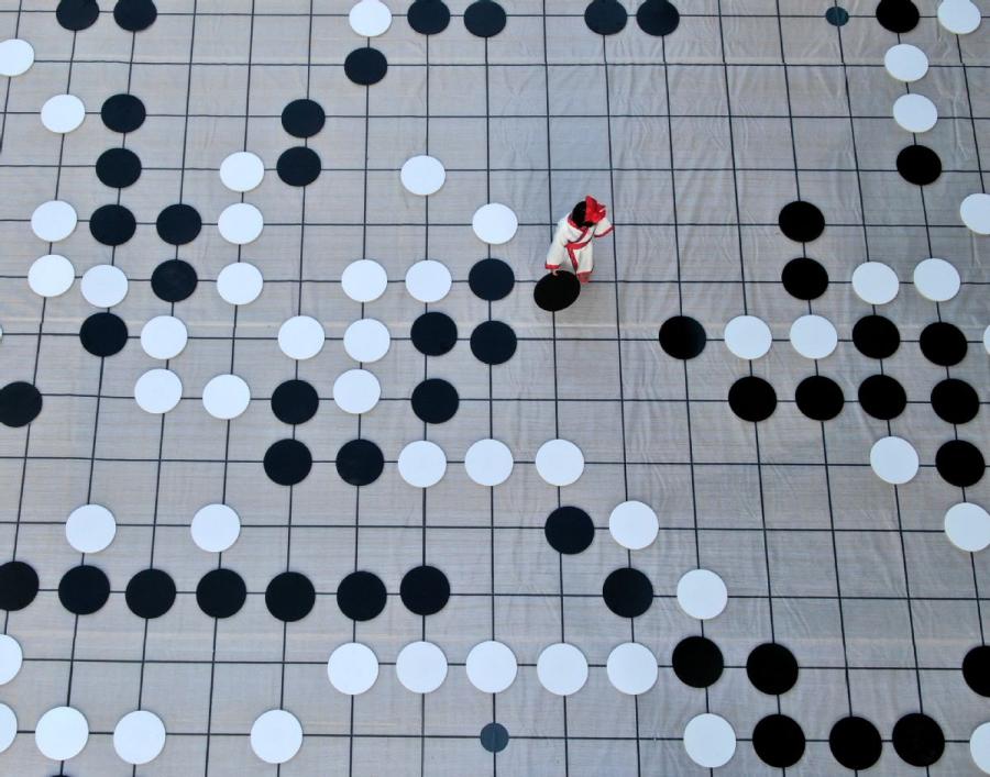 A player places a piece during a game of go on the sidelines of the finals of the third Chinese Weiqi Sage Title competition on Luoyang\'s Baiyun mountain in Henan Province, Nov. 12.  (Photo/Asianewsphoto)