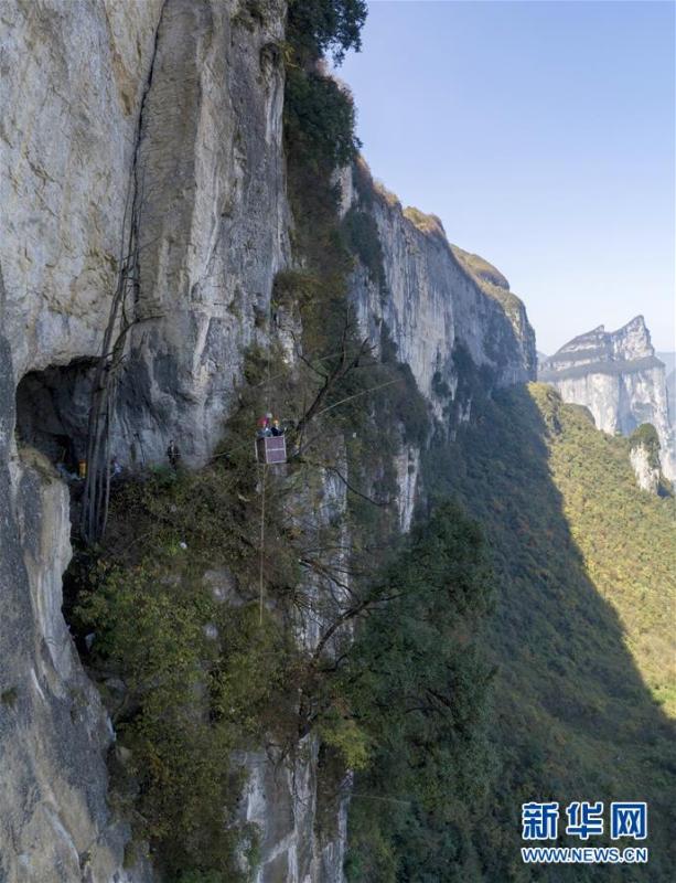 Water exploration team members reach the Tianbao cave in Tianfengping village by using an iron basket, Oct. 31, 2018.  (Photo/Xinhua)