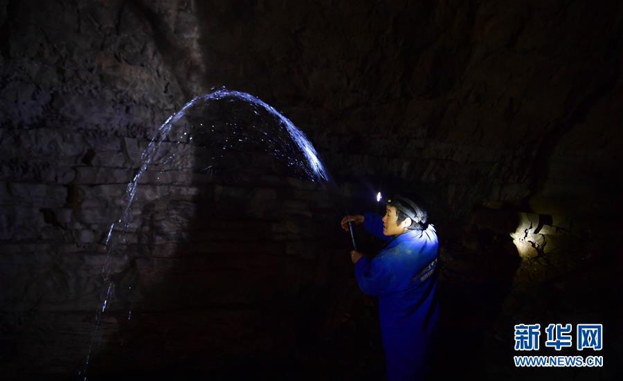A water exploration team member uses pipes to draw water from the Tianbao cave in Tianfengping village, Enshi city, Central China\'s Hubei Province, Oct. 31, 2018.  (Photo/Xinhua)