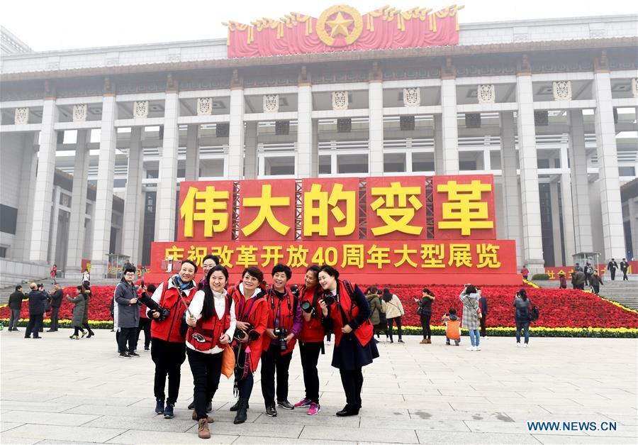 Visitors pose for photos in front of the National Museum of China, where a major exhibition to commemorate the 40th anniversary of China\'s reform and opening-up is held, in Beijing, capital of China, Nov. 14, 2018. (Xinhua/Luo Xiaoguang)