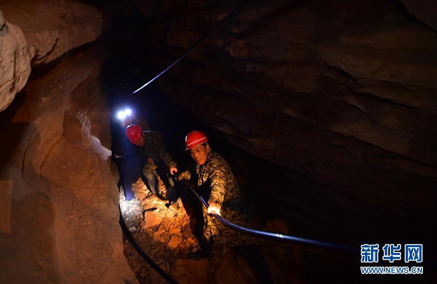 Water exploration team members lay water pipes in the Tianbao cave in Tianfengping village, Enshi city, Central China\'s Hubei Province, on Nov. 13, 2018. (Photo/Xinhua)