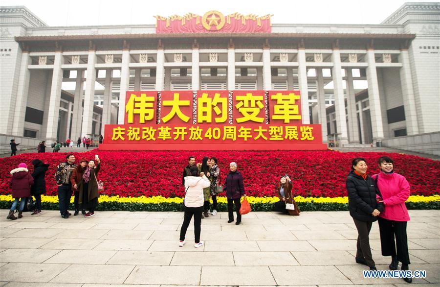 Visitors take photos in front of the National Museum of China, where a major exhibition to commemorate the 40th anniversary of China\'s reform and opening-up is held, in Beijing, capital of China, Nov. 14, 2018. The exhibition opened here on Tuesday. (Xinhua/Meng Dingbo)