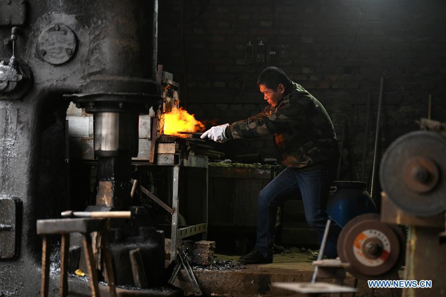 Li Zhujun makes a decorative sword at his studio in Tiejiangzhuang Village of Xingtang County, Shijiazhuang, north China\'s Hebei Province, Nov. 14, 2018. For centuries, Tiejiangzhuang Village has been famed for its skillful blacksmiths and prosperous steel making industry. Li Zhujun is one of the village\'s top steel makers. Based on the skills inherited from his father, Li gained an expertise in the steel-making technique \