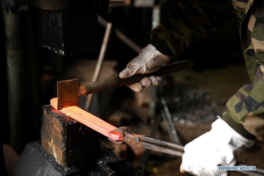 Li Zhujun makes a decorative sword at his studio in Tiejiangzhuang Village of Xingtang County, Shijiazhuang, north China\'s Hebei Province, Nov. 14, 2018. For centuries, Tiejiangzhuang Village has been famed for its skillful blacksmiths and prosperous steel making industry. Li Zhujun is one of the village\'s top steel makers. Based on the skills inherited from his father, Li gained an expertise in the steel-making technique \