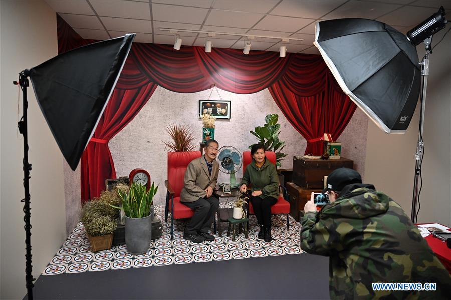 Two visitors pose for photos in a vintage image studio set at a major exhibition to commemorate the 40th anniversary of China\'s reform and opening-up at the National Museum of China in Beijing, capital of China, Nov. 15, 2018. Vintage objects are displayed at the exhibition which opened here on Tuesday to show visitors the history, accomplishments, and experience of China\'s reform and opening-up.(Xinhua/Li Xin)
