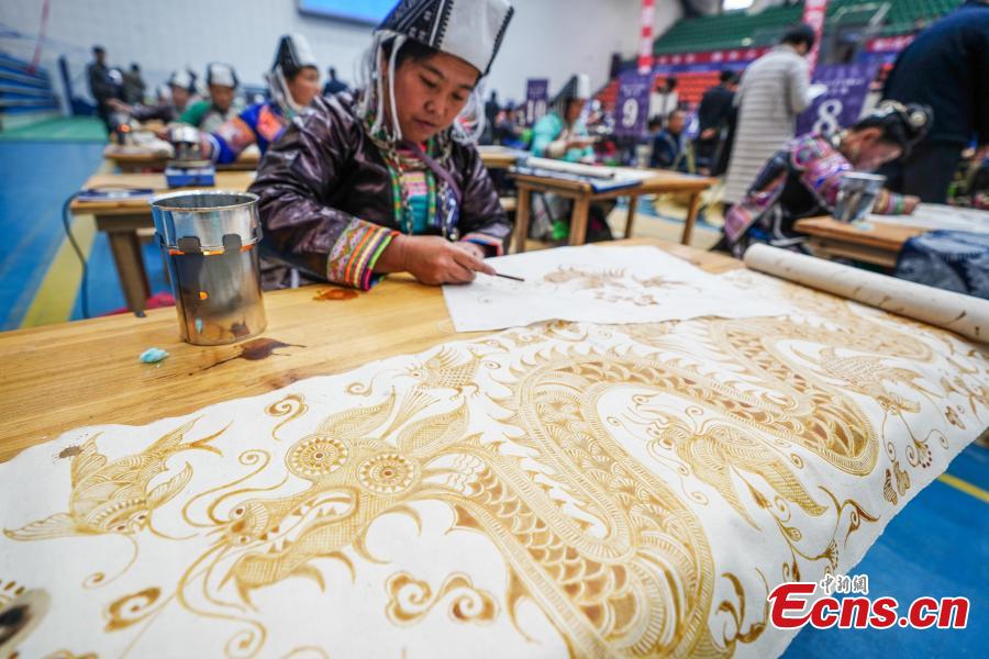 A competitor presents wax printing skills during a manual skills competition held in Rongjiang County of Qiandongnan Miao and Dong Autonomous Prefecture, southwest China\'s Guizhou Province, on Nov. 15, 2018. A number of artisans from the county participated in the competition in aspects of spinning, weaving, wax printing, embroidery and so on.(Photo: China News Service/ He Junyi)