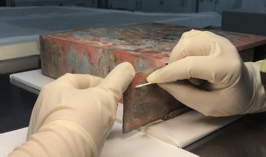 The photo shows “baoxia”, or ancient treasure box once placed in the Hall of Mental Cultivation in the Palace Museum in Beijing. The treasure box, made of tin and oblate in a square shape, was the first painted treasure box discovered in the Forbidden City. The box was contained many things inside, including scriptures, coins, shoe-shaped ingots in five materials of gold, silver, copper, iron, and tin, gems in five colors, satins in five colors, silk threads in five colors, five spices, five medicines and five cereals. Such boxes were placed in the ridge cylinder in the center of the main ridge on the roof as an item for suppressing evil. During ancient times, placement of the treasure box featured a grand ceremony to pray for safety.(Photo provided to China News Service)