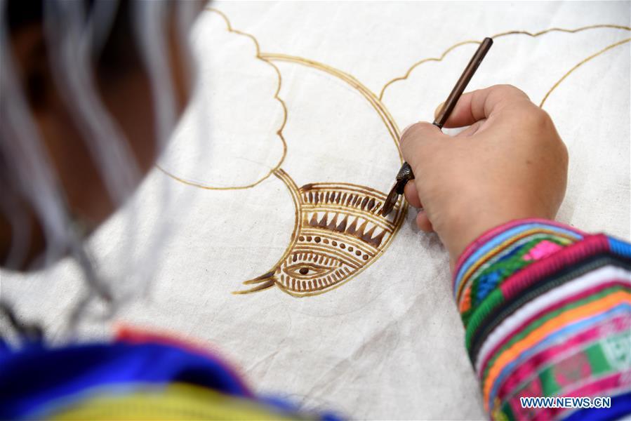 A competitor presents wax printing skills during a manual skills competition held in Rongjiang County of Qiandongnan Miao and Dong Autonomous Prefecture, southwest China\'s Guizhou Province, on Nov. 15, 2018. A number of artisans from the county participated in the competition in aspects of spinning, weaving, wax printing, embroidery and so on. (Xinhua/Liu Jinyin)