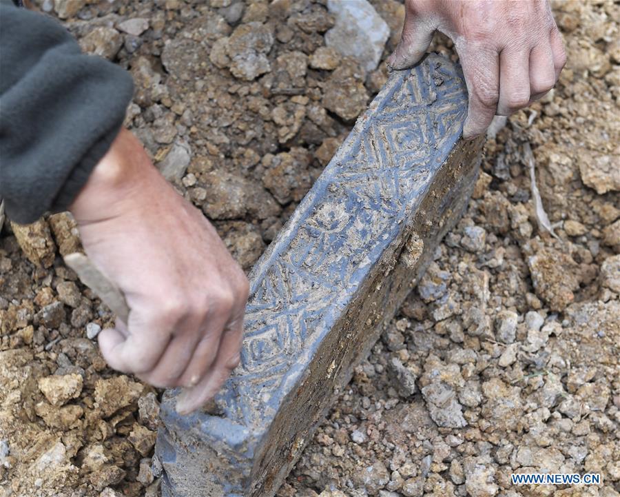 A worker cleans a brick from a tomb dated from the Eastern Han Dynasty (25-220) discovered in Chenghua District of Chengdu, capital of southwest China\'s Sichuan Province, Nov. 15, 2018. Altogether four tombs from the Eastern Han Dynasty (25-220) were discovered here in October this year, according to the Chengdu cultural relics and archeology research institute. (Xinhua/Liu Kun)