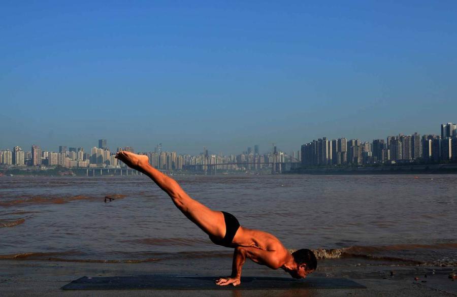Wang Wanming, 61, a retiree in Southwest China\'s Chongqing municipality, has been practicing yoga almost every day by the Yangtze River for six years. His technique has made him a local celebrity. (Photo provided to chinadaily.com.cn)