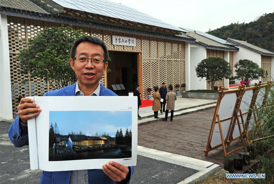 Ding Wei, a designer from south China\'s Guangdong Province, shows the effect picture of a building in Lujia Village of Anji County, east China\'s Zhejiang Province, Nov. 14, 2018. Lujia Village is located in the mountainous region in northeastern Anji. The village has a population of over 2,200 and about 533 hectares of bamboo forests. To build a beautiful village and improve the living of local villagers, Lujia implemented a comprehensive plan for rural, industrial and tourism development in recent years. The income of the village\'s collective economy surged from 18,000 yuan (about 2,500 U.S. dollars) in 2011 to 3.3 million yuan (about 475,000 U.S. dollars) in 2017. The per capita income of local people arrives at 35,000 yuan (about 5,000 U.S. dollars). So far, the village has collective assets valued at nearly 200 million yuan (about 28.8 million U.S. dollars). (Xinhua/Tan Jin)