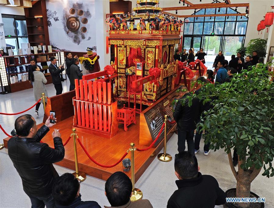 Tourists view a traditional sedan chair made by local carpenter Guo Jinxian in Lujia Village of Anji County, east China\'s Zhejiang Province, Nov. 16, 2018. Lujia Village is located in the mountainous region in northeastern Anji. The village has a population of over 2,200 and about 533 hectares of bamboo forests. To build a beautiful village and improve the living of local villagers, Lujia implemented a comprehensive plan for rural, industrial and tourism development in recent years. The income of the village\'s collective economy surged from 18,000 yuan (about 2,500 U.S. dollars) in 2011 to 3.3 million yuan (about 475,000 U.S. dollars) in 2017. The per capita income of local people arrives at 35,000 yuan (about 5,000 U.S. dollars). So far, the village has collective assets valued at nearly 200 million yuan (about 28.8 million U.S. dollars). (Xinhua/Tan Jin)