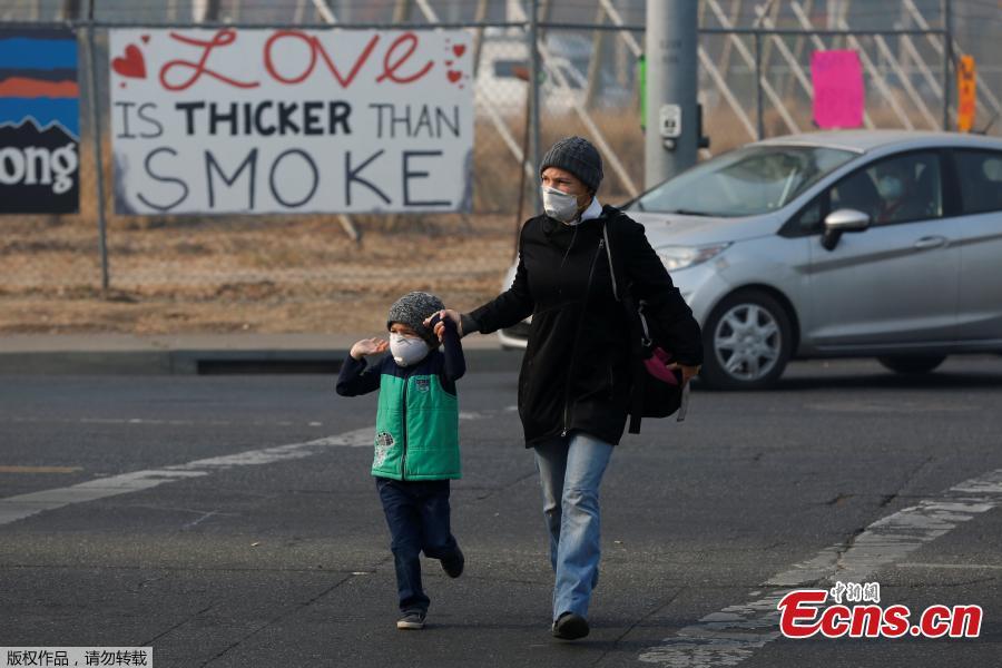 Leanne Brickett and her son, Aiden, 5, wear masks to protect themselves from smoke from the Camp Fire in Chico, California, U.S., November 18, 2018.   (Photo/Agencies)