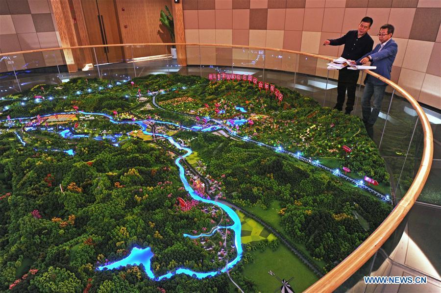 Zhu Renbin (L), secretary of the Communist Party of China local branch in Lujia Village, discusses the village\'s development plan with Ding Wei, a designer from south China\'s Guangdong Province, in Lujia of Anji County, east China\'s Zhejiang Province, Nov. 14, 2018. Lujia Village is located in the mountainous region in northeastern Anji. The village has a population of over 2,200 and about 533 hectares of bamboo forests. To build a beautiful village and improve the living of local villagers, Lujia implemented a comprehensive plan for rural, industrial and tourism development in recent years. The income of the village\'s collective economy surged from 18,000 yuan (about 2,500 U.S. dollars) in 2011 to 3.3 million yuan (about 475,000 U.S. dollars) in 2017. The per capita income of local people arrives at 35,000 yuan (about 5,000 U.S. dollars). So far, the village has collective assets valued at nearly 200 million yuan (about 28.8 million U.S. dollars). (Xinhua/Tan Jin)