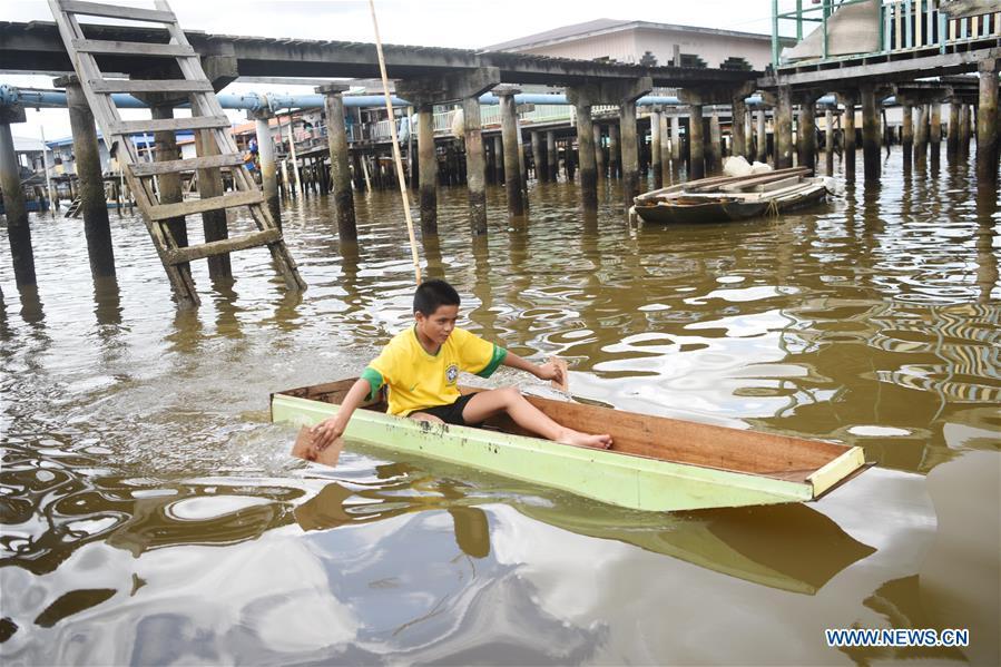 A boy plays in a self-made boat at the Water Village in Bandar Seri Begawan, capital of Brunei, on Nov. 18, 2018. (Xinhua/Wang Shen)