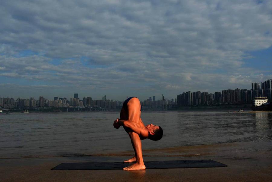 Wang Wanming, 61, a retiree in Southwest China\'s Chongqing municipality, has been practicing yoga almost every day by the Yangtze River for six years. His technique has made him a local celebrity. (Photo provided to chinadaily.com.cn)