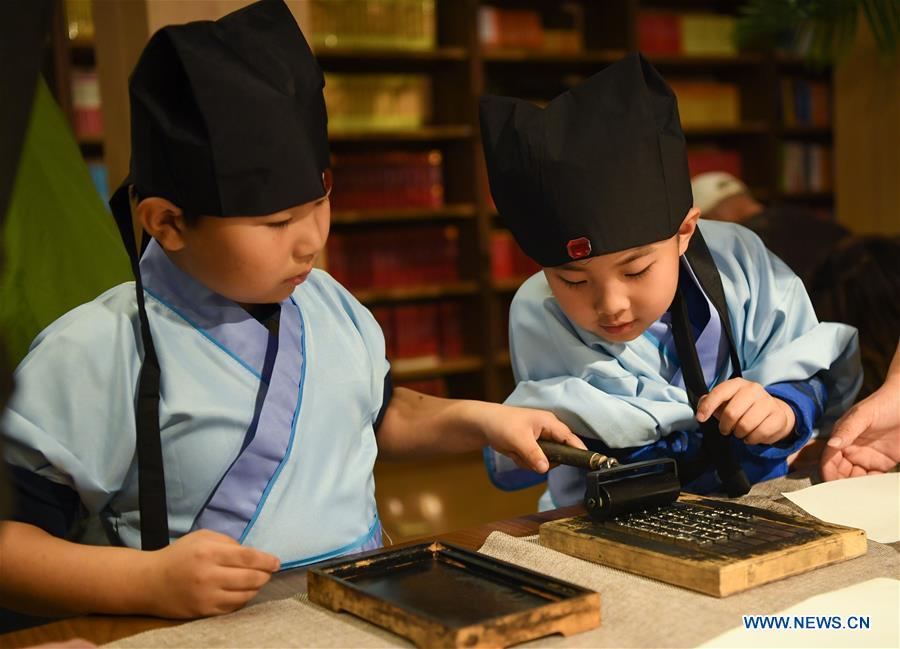 Primary school students experience the processes of movable-type printing in Shenyang, capital of northeast China\'s Liaoning Province, Nov. 18, 2018. (Xinhua/Long Lei)
