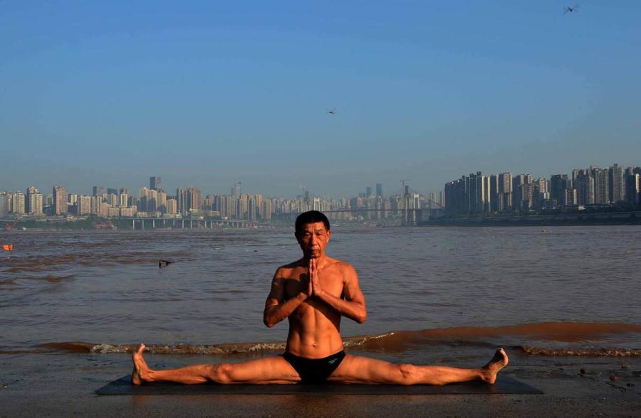 Wang Wanming, 61, a retiree in Southwest China\'s Chongqing municipality, has been practicing yoga almost every day by the Yangtze River for six years. His technique has made him a local celebrity. (Photo provided to chinadaily.com.cn)