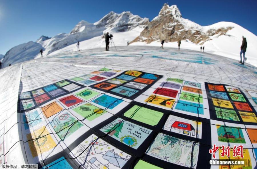 A giant postcard of approximately 2500 square meters made of contributions from over 125\'000 individual postcards containing messages aiming to fight climate change and global warming, is pictured on the Aletsch glacier near the Jungfraujoch saddle by the Jungfrau peak, in Switzerland, Nov 16, 2018. (Photo/Agencies)