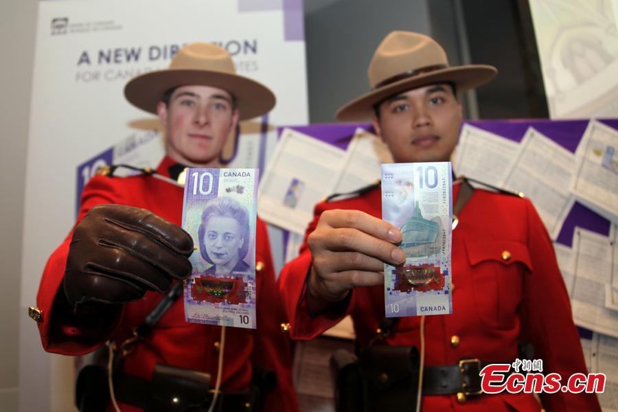 People hold a $10 banknote featuring Viola Desmond in Toronto, Canada, Nov. 19, 2018. The banknote is the first vertically oriented bill in Canada and the first regularly circulating banknote to feature a Canadian woman, civil rights advocate Viola Desmond, on the front. (Photo: China News Service/Yu Dongrui)