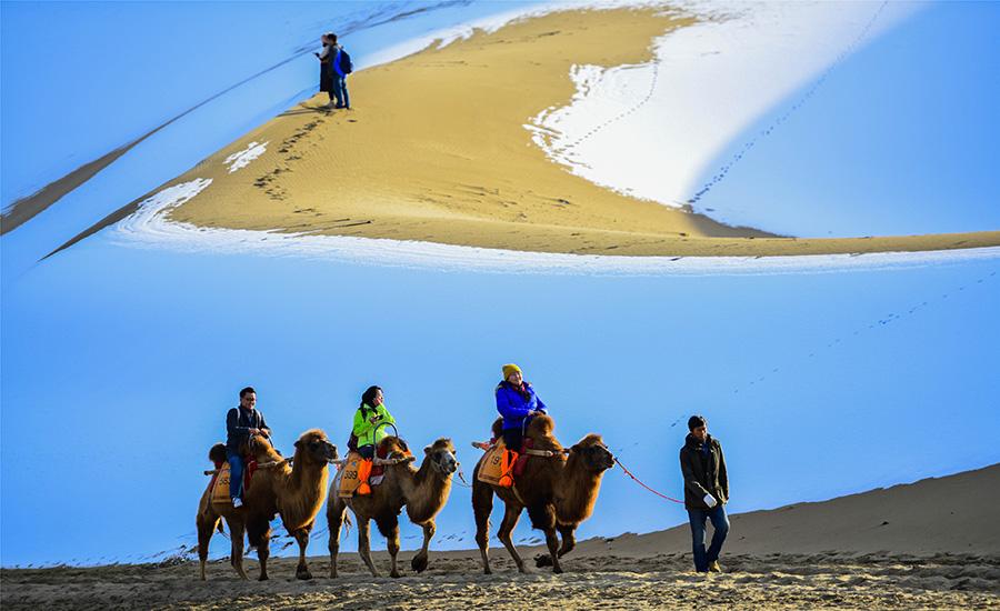 Dunhuang embraces this winter\'s first snowfall on Nov. 14. As the sun comes out, snow scenery in local landmark attractions like the Mingsha Mountain and Yueya Spring, a crescent-shaped spring-fed lake surrounded by desert, turns to a fairyland. (Photo/China Daily)
