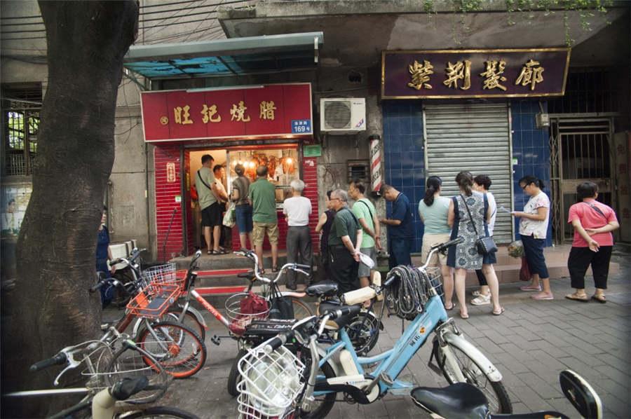 People line up in front of the cured meat shop of a time-honored brand in Liwan district of Guangzhou city in South China\'s Guangdong Province, July 31, 2018. (Photo provided to chinadaily.com.cn)