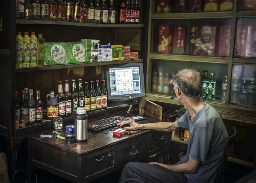 An elderly man plays chess online in Huzhou city, East China\'s Zhejiang province, May 25, 2014.  (Photo provided to chinadaily.com.cn)