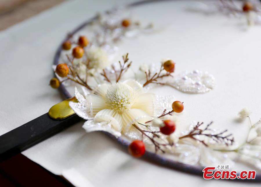 Liu Yao, a girl from northwestern China city Lanzhou, shows her embroidery works featuring patterns made of preserved flowers. With stitching techniques of Suzhou Embroidery and beading skills, the girl, an embroidery lover, makes her works with colorful dried flowers. (Photo: China News Service/ Gao Zhan)