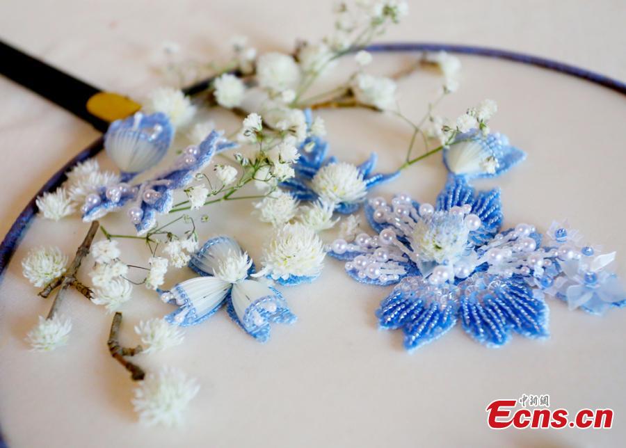 Liu Yao, a girl from northwestern China city Lanzhou, shows her embroidery works featuring patterns made of preserved flowers. With stitching techniques of Suzhou Embroidery and beading skills, the girl, an embroidery lover, makes her works with colorful dried flowers. (Photo: China News Service/ Gao Zhan)