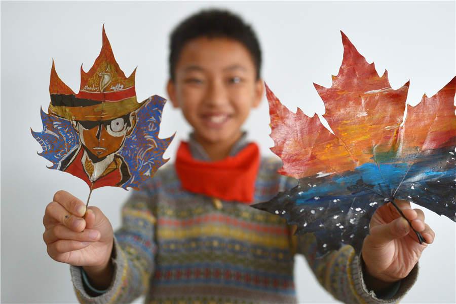 A student shows his leaf art at a primary school in Qingdao, East China\'s Shandong Province, on Nov. 19, 2018. (Photo/Asianewsphoto)

Students from a primary school in Qingdao city, Shandong Province have created leaf art through drawing and carving. Liu Ping, an art teacher at the school who is enthusiastic about the style, provides guidance to students during the process.
