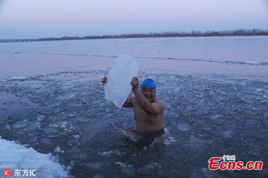 A winter swimming enthusiast broke the ice and jumped into the Songhua River to start his winter swimming season in Harbin, Northeast China\'s Heilongjiang province, on Nov 23, 2018. Hundreds of winter swimming enthusiasts swim in the river every year. (Photo/VCG)