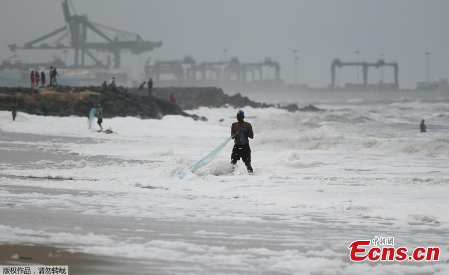 An Indian fisherman pulls in his fishing net as foamy discharge, caused by pollutants, mix with surf at a beach in Chennai on November 22, 2018. High levels of sewage and industrial waste was claimed to be the cause of the foam, officials said.(Photo/Agencies)