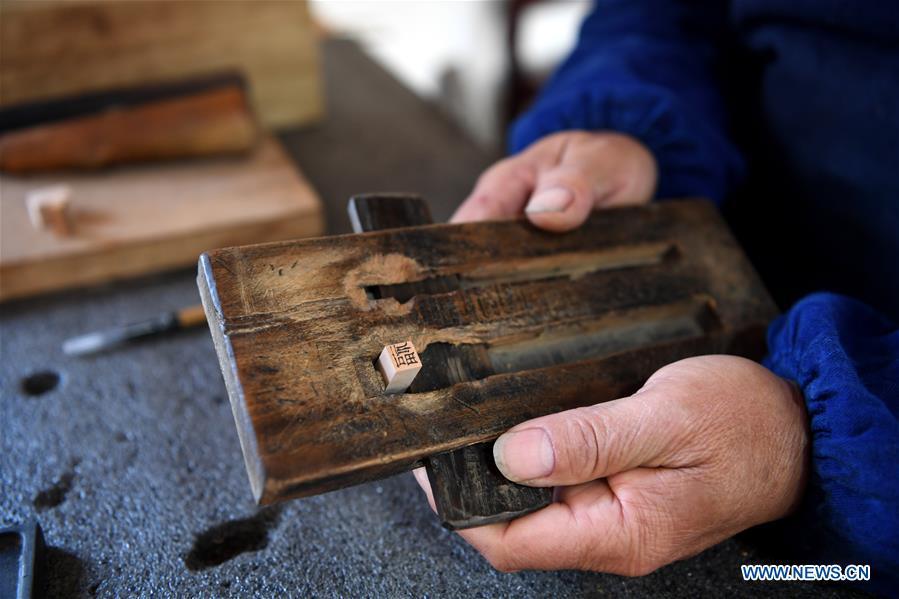 Lei Shitai presents his printing tools in Chanshan Village of Qinxi Town, Jingxian County, in east China\'s Anhui Province, Nov. 23, 2018. Lei, 52, born in neighboring Jiangxi Province, started his career as a typography printer when he finished his apprenticeship with his uncle who he followed since he was 17. The traditional printing method witnessed an increasingly hard time in the recent years as a livelihood. It was in 2017 when he decided to move to Chanshan at the invitation of Kai Yuanhong, a local cabinet maker, to cooperate in a broader way. Lei is now working with the traditional technique in a larger scale. (Xinhua/Liu Junxi)