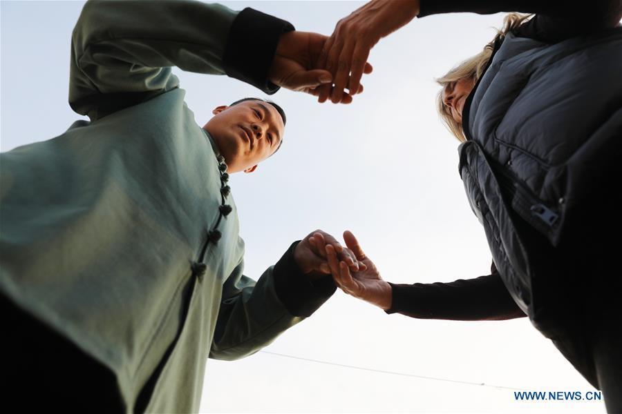 Ana Fidalgo (R) practices Taiji under the guidance of coach Chen Chao in Chenjiagou Village of Wenxian County, central China\'s Henan Province, Nov. 25, 2018. Ana, who comes from Sao Paulo, Brazil, loves Chinese culture, and is a fan of Taiji. It\'s the third time that she comes to Chenjiagou Village to study Taiji. She has taught what she has learned in China in her hometown when coming back to Brazil in recent years, hoping to benefit more people. (Xinhua/Xu Hongxing)