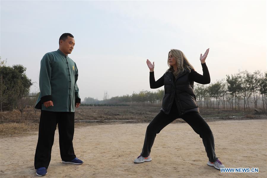 Ana Fidalgo (R) practices Taiji under the guidance of coach Chen Chao in Chenjiagou Village of Wenxian County, central China\'s Henan Province, Nov. 25, 2018. Ana, who comes from Sao Paulo, Brazil, loves Chinese culture, and is a fan of Taiji. It\'s the third time that she comes to Chenjiagou Village to study Taiji. She has taught what she has learned in China in her hometown when coming back to Brazil in recent years, hoping to benefit more people. (Xinhua/Xu Hongxing)