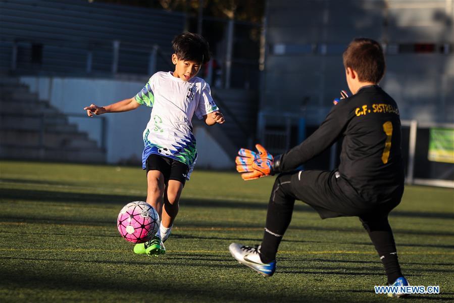 Xu Tianze (L) drives the ball during a match against Club Sistrells in Badalona, Province of Barcelona, Spain, Nov. 24, 2018. Spain has a mature football industry which attracts many young Chinese football lovers. The Sport CSKH, founded by an overseas Chinese in Barcelona, has been a bridge linking Chinese young football players with Spanish football culture. (Xinhua/Zheng Huansong)