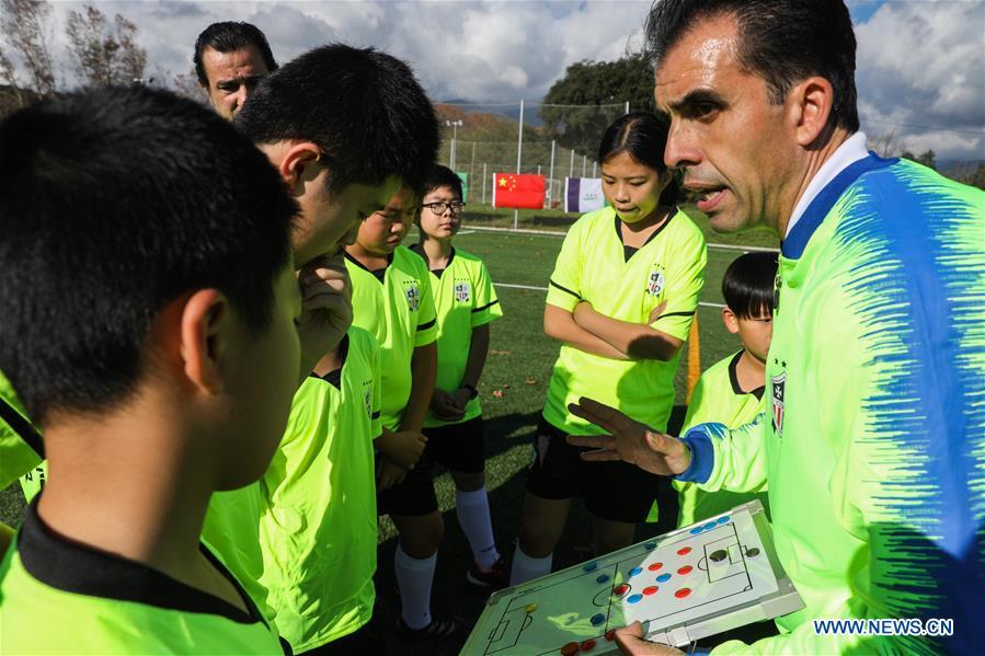 Coach Miguel Duran (R) instructs Chinese young football players at the Sport CSHK training ground in Sant Esteve de Palautordera, Province of Barcelona, Spain, Nov. 24, 2018. Spain has a mature football industry which attracts many young Chinese football lovers. The Sport CSKH, founded by an overseas Chinese in Barcelona, has been a bridge linking Chinese young football players with Spanish football culture. (Xinhua/Zheng Huansong)