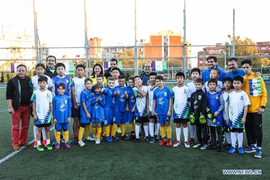 Chinese young football players pose for photos with members of Club Sistrells after their match in Badalona, Province of Barcelona, Spain, Nov. 24, 2018. Spain has a mature football industry which attracts many young Chinese football lovers. The Sport CSKH, founded by an overseas Chinese in Barcelona, has been a bridge linking Chinese young football players with Spanish football culture. (Xinhua/Zheng Huansong)